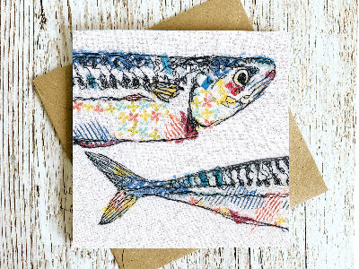 Card with a colorful fish illustration on a wooden surface