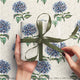 Gift wrapped with a green ribbon on floral-patterned paper