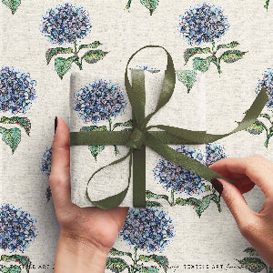 Gift wrapped with a green ribbon on floral-patterned paper