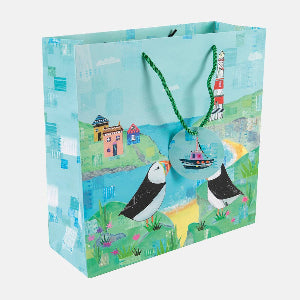 Gift bag with puffins and coastal scene design on a white background