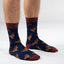 Person wearing blue socks with rooster pattern on a white background