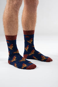 Person wearing blue socks with rooster pattern on a white background